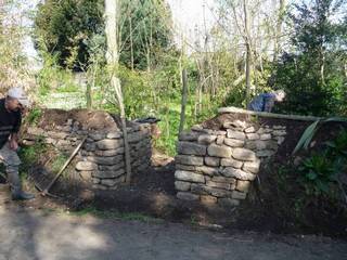 au village on termine l'entrée du jardin à l'intérieur duquel se trouvent une petite fontaine, et une pierre meulière.
